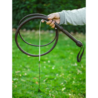Person holding a chocolate brown cowhide bullwhip outdoors