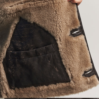 Close-up detail of genuine cowhide leather exterior and soft faux-fur shearling collar on a vintage brown winter jacket, showcasing the leather texture, stitching, warm lining, and premium rugged finish