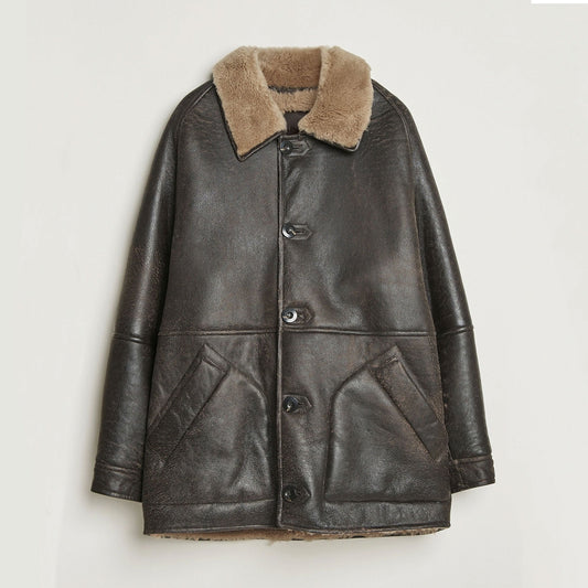 Front view of vintage brown cowhide leather shearling winter jacket with plush faux-fur collar, button-front closure, structured silhouette, and two angled front pockets displayed against a clean studio background